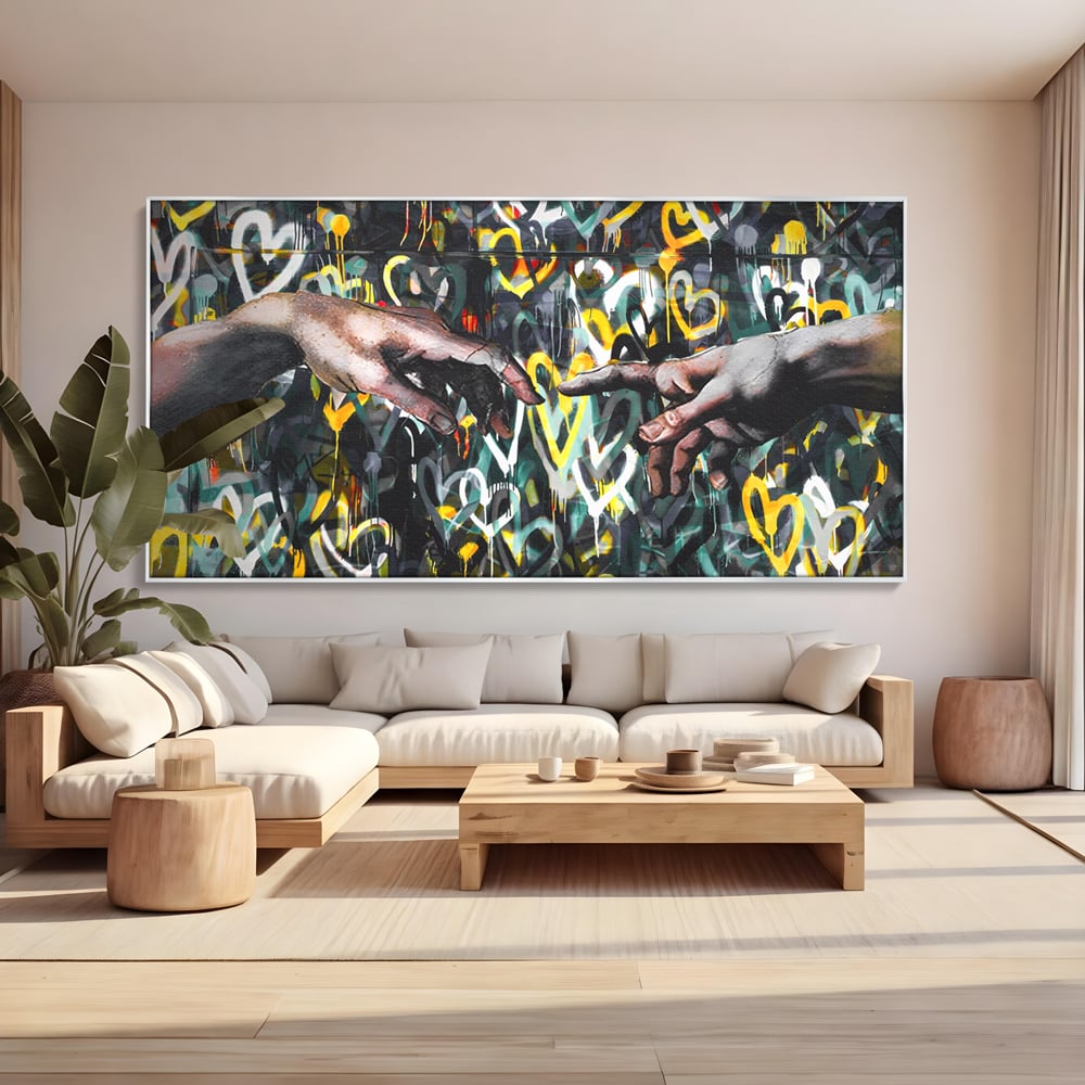 Tablou canvas cu tablou canvas cu maini si inimi, in rama de aluminiu argintiu, pe perete intr-un living